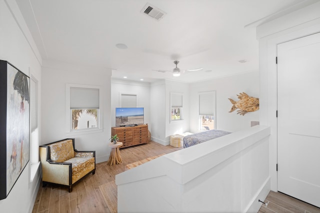 bedroom featuring light wood-type flooring, ceiling fan, and crown molding