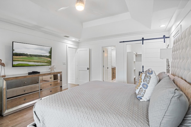 4639 Destiny Way, Destin, FL 32541 - bedroom featuring a raised ceiling, a barn door, wood finished floors, recessed lighting, and ensuite bathroom