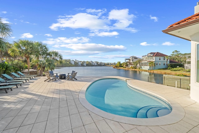 view of swimming pool with a water view and a patio