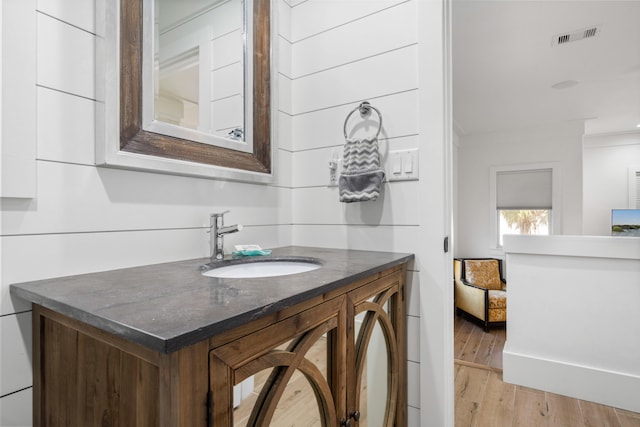 bathroom with vanity, wood-type flooring, and crown molding