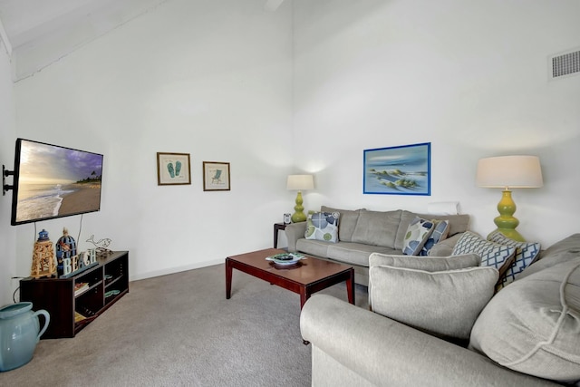 carpeted living room featuring a towering ceiling