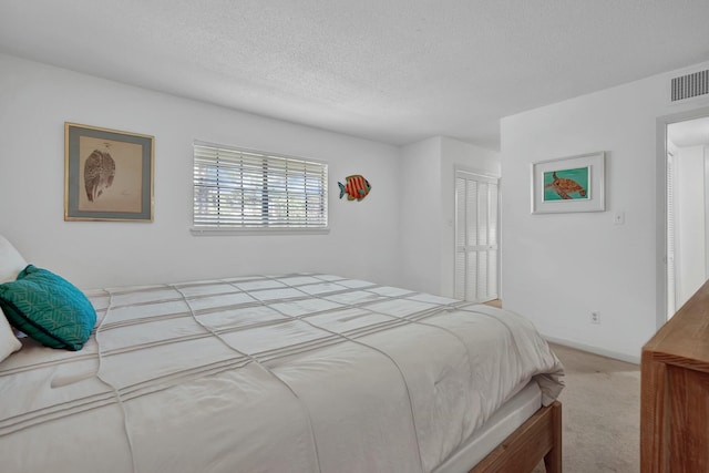 carpeted bedroom featuring a textured ceiling and a closet