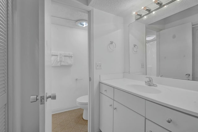 bathroom featuring vanity, a textured ceiling, and toilet