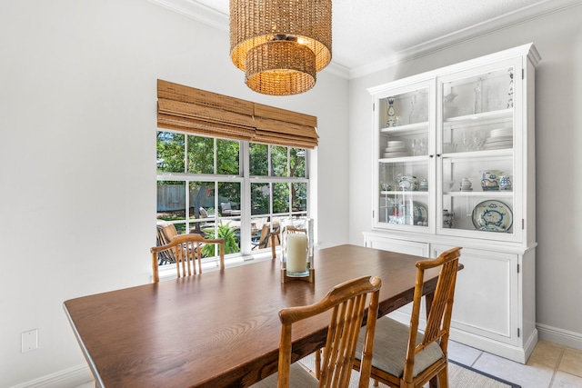 tiled dining area featuring an inviting chandelier and ornamental molding