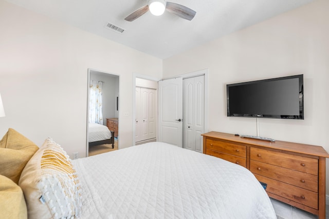 bedroom with two closets and a ceiling fan