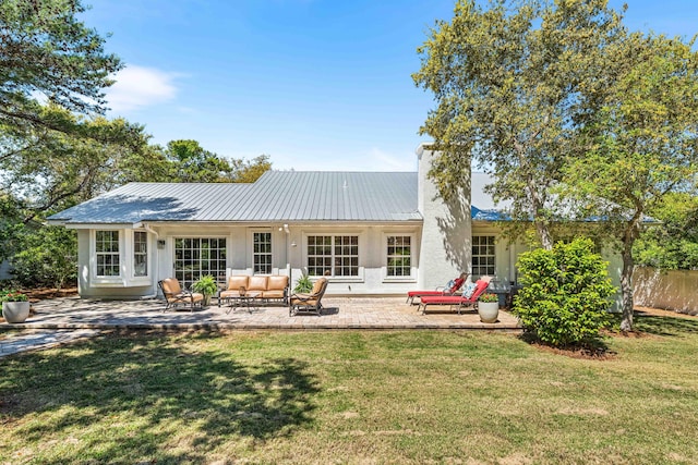 rear view of property with an outdoor hangout area, a chimney, metal roof, and a patio