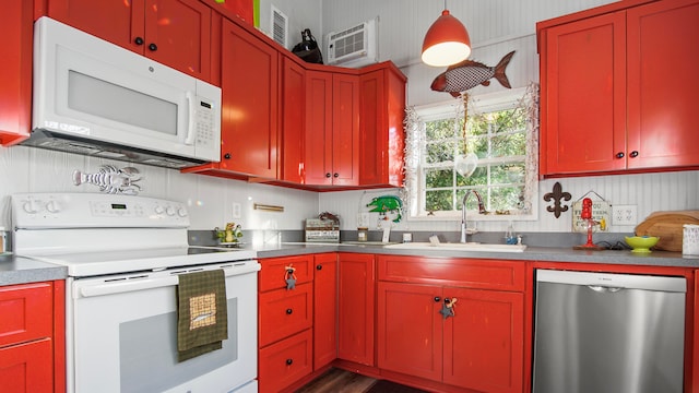 kitchen featuring decorative light fixtures, white appliances, sink, and a wall mounted air conditioner