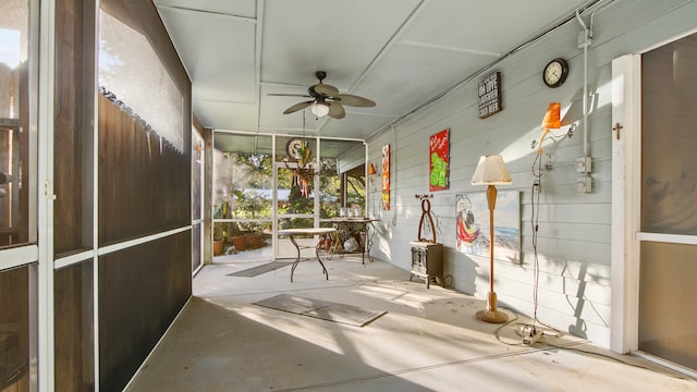 unfurnished sunroom featuring ceiling fan