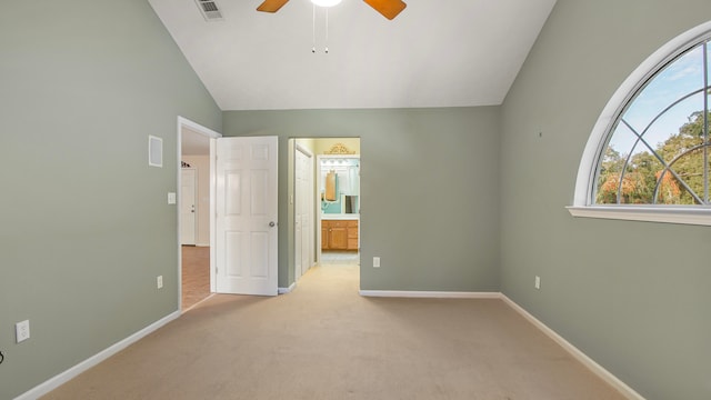 unfurnished bedroom with connected bathroom, lofted ceiling, light colored carpet, and ceiling fan