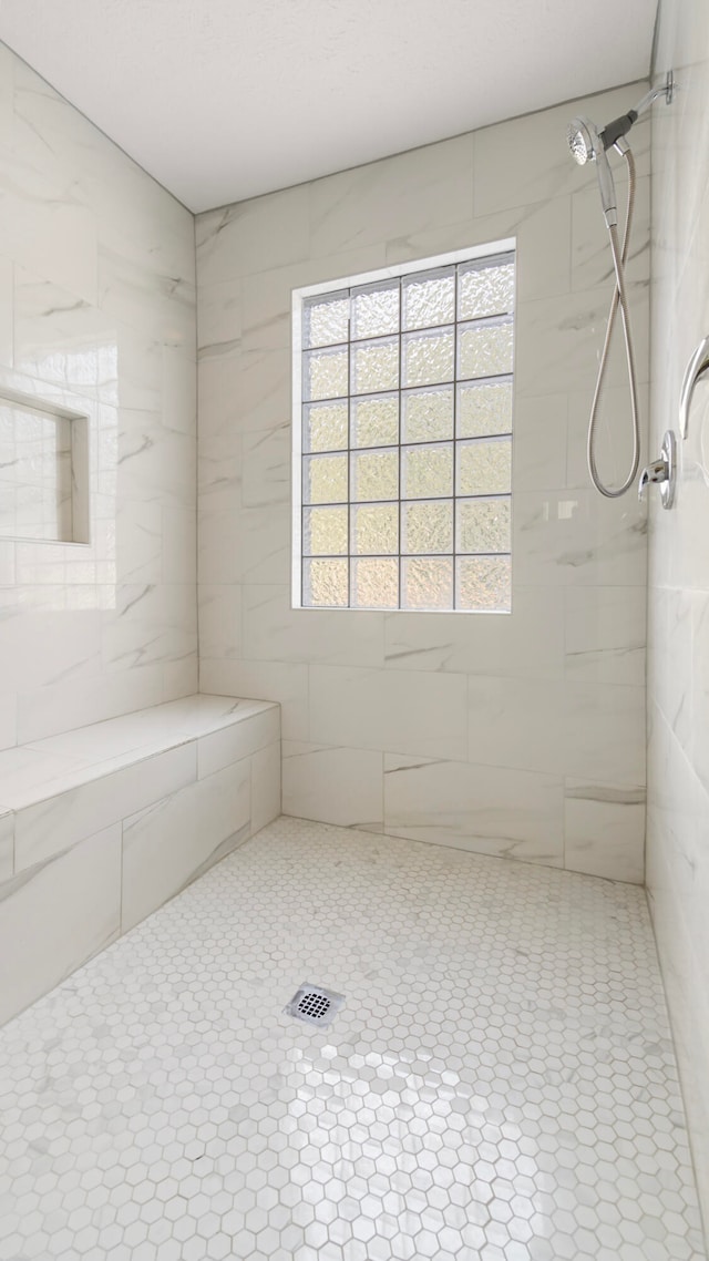 bathroom with tile patterned floors and a tile shower