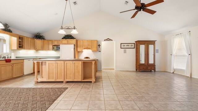 kitchen featuring white appliances, a healthy amount of sunlight, and a kitchen island