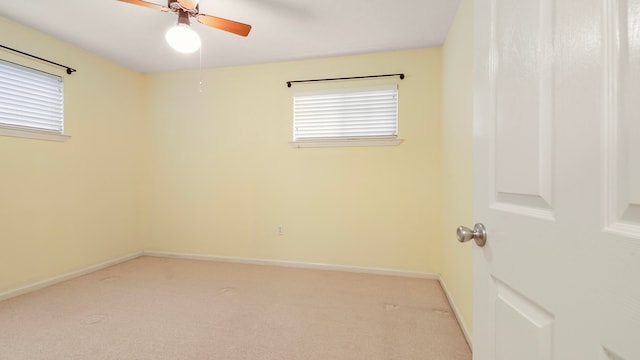 carpeted spare room featuring ceiling fan