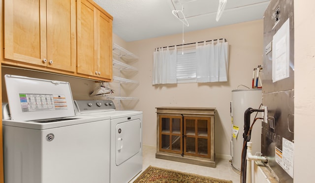 clothes washing area with heating unit, water heater, cabinets, and washer and dryer