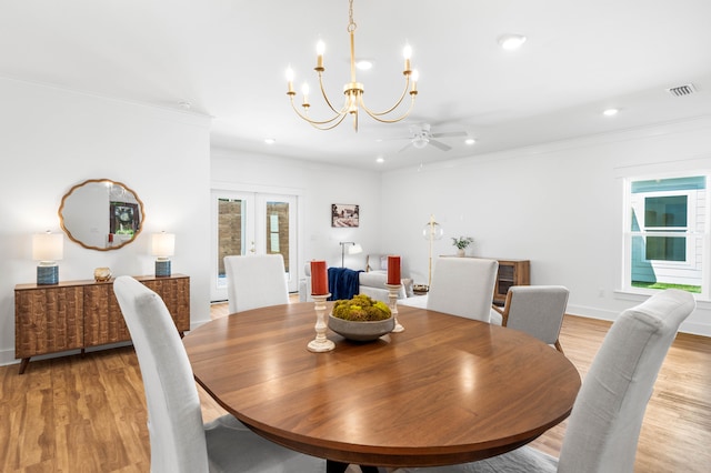 dining area with french doors, ceiling fan with notable chandelier, light hardwood / wood-style floors, and crown molding