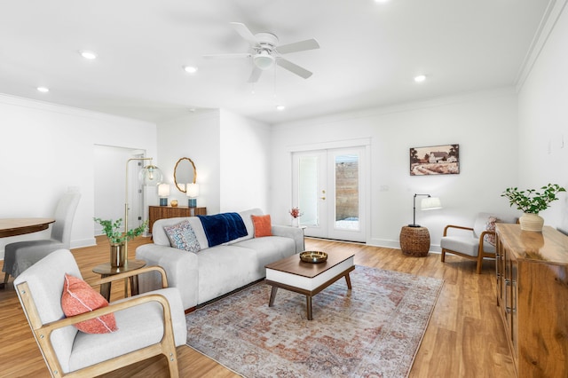 living room with ceiling fan, light wood-type flooring, ornamental molding, and french doors