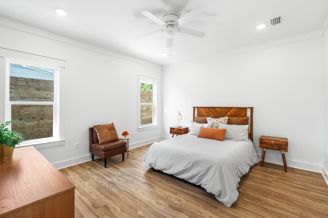 bedroom with light wood-type flooring, ceiling fan, and ornamental molding