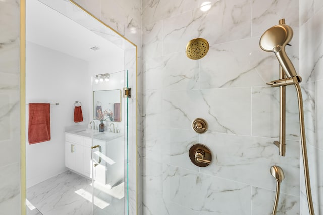 bathroom with a tile shower and vanity