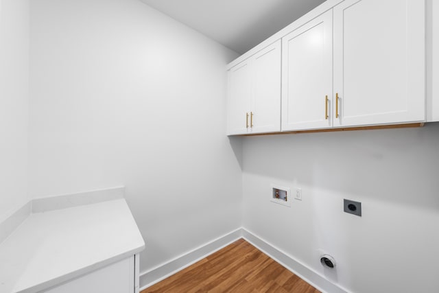 clothes washing area featuring hookup for an electric dryer, washer hookup, cabinets, and light hardwood / wood-style flooring