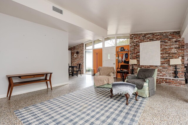 living room with vaulted ceiling with beams and brick wall