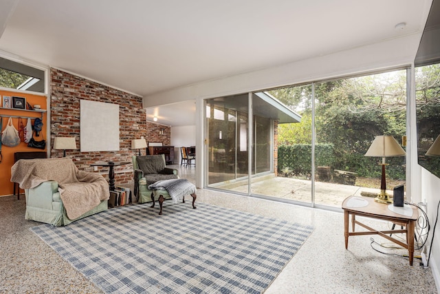 living room featuring plenty of natural light and brick wall