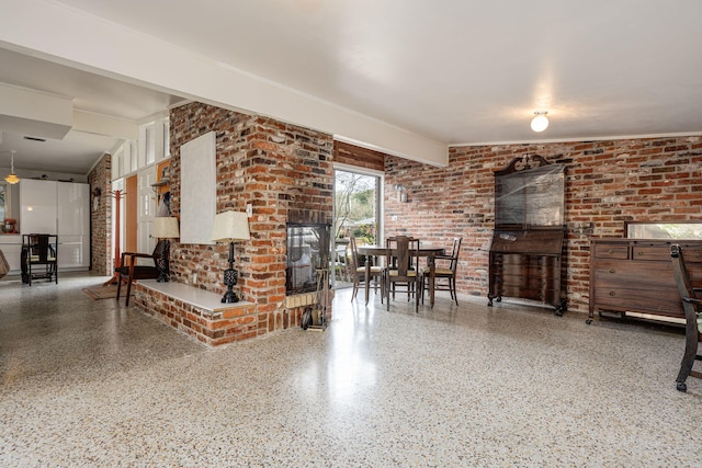 living room with beamed ceiling and brick wall