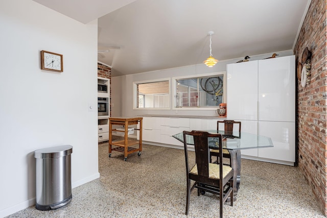 dining space featuring brick wall