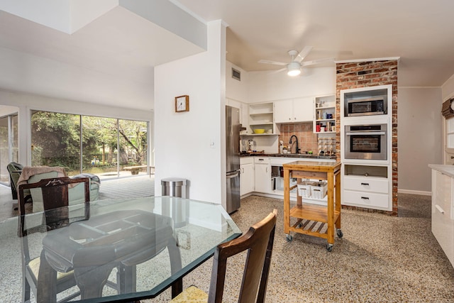 dining area with ceiling fan and sink