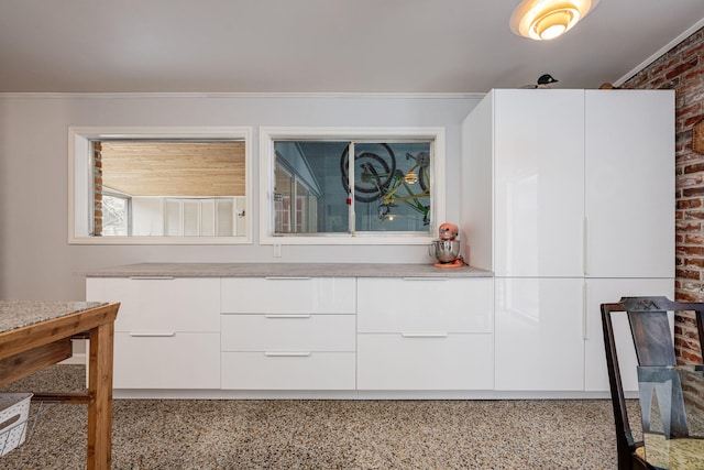 interior space with crown molding and brick wall