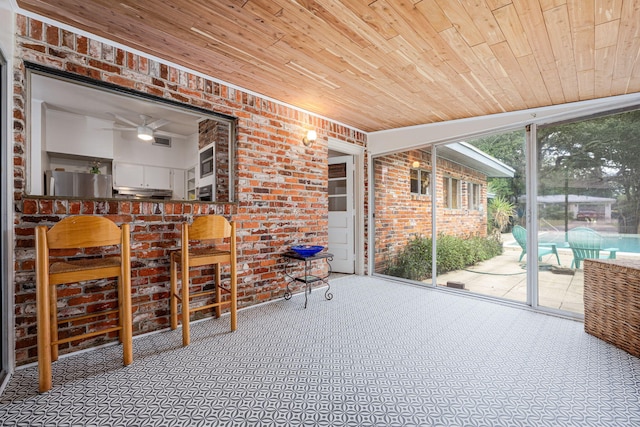 sunroom / solarium with ceiling fan and wooden ceiling