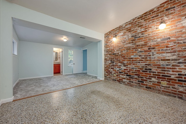 empty room featuring brick wall