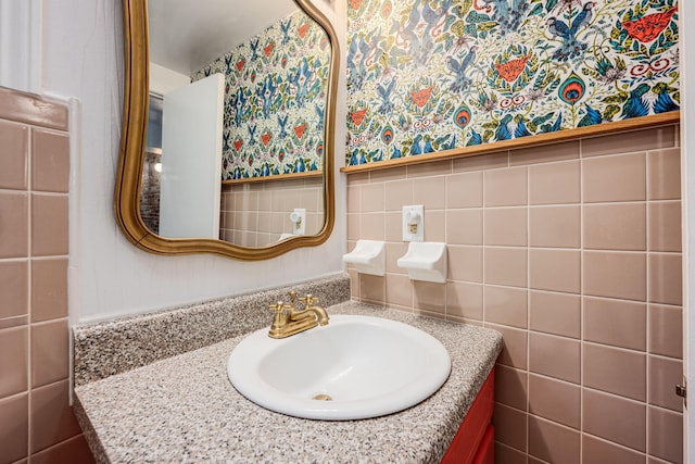 bathroom with vanity and tile walls