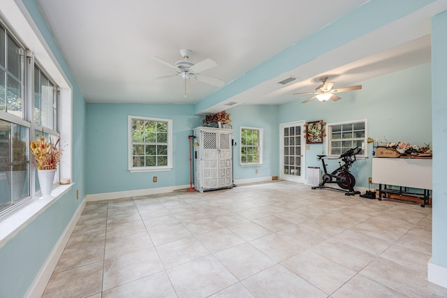 workout room featuring ceiling fan and light tile patterned floors