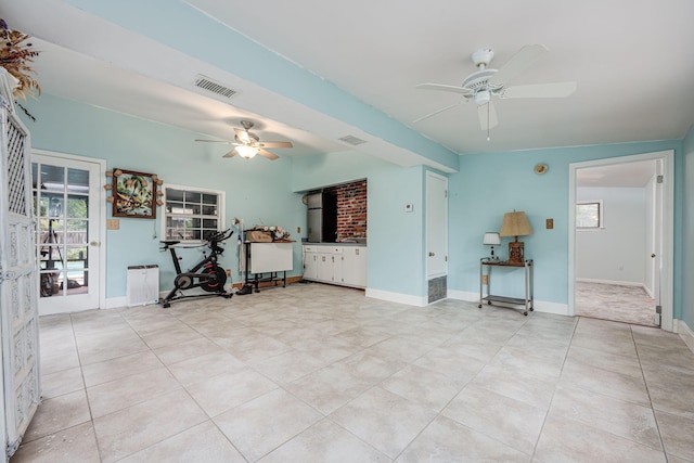 unfurnished living room featuring ceiling fan and light tile patterned floors