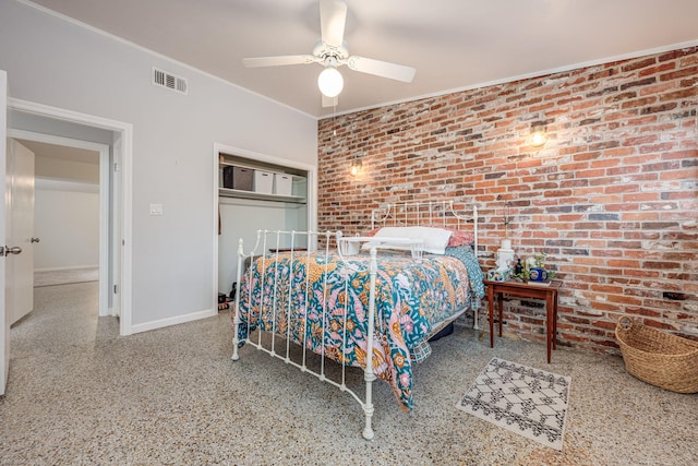 bedroom featuring ceiling fan, brick wall, and a closet