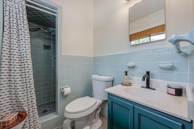 bathroom with a tile shower, vanity, tile walls, and toilet