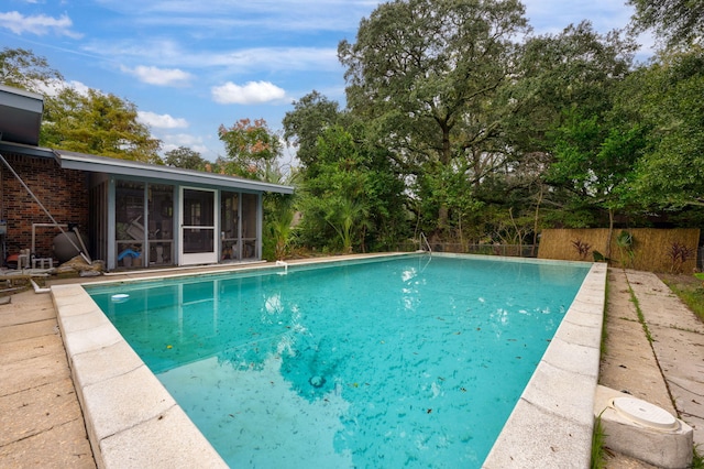 view of swimming pool featuring a sunroom