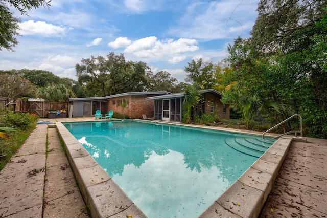 view of swimming pool with a sunroom and a patio