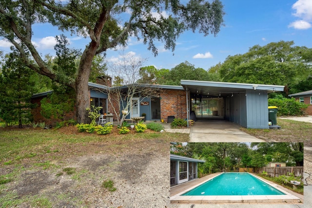 back of house with a carport and a fenced in pool