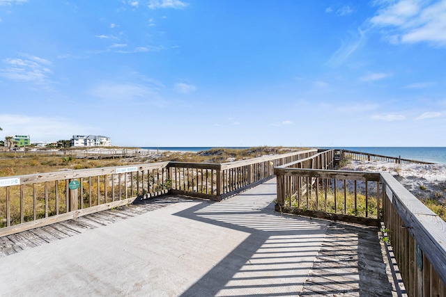 wooden deck with a water view and a view of the beach