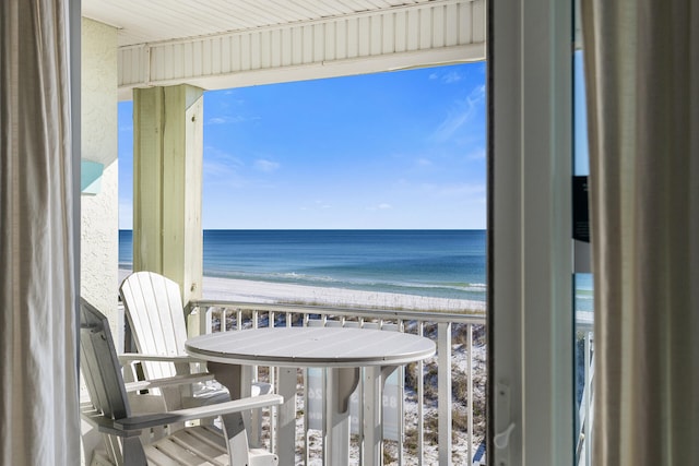 balcony with a water view and a beach view