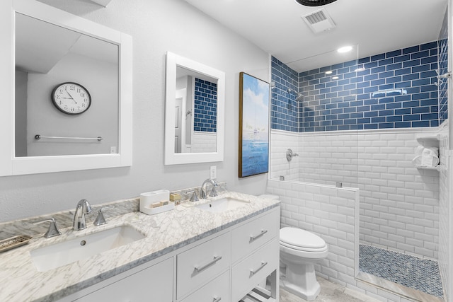 bathroom featuring tiled shower, vanity, and toilet