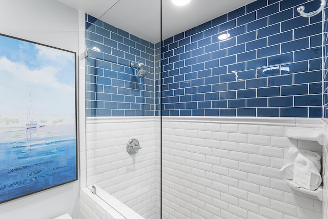 bathroom with tiled shower and tile walls