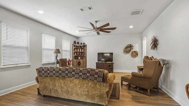 living area featuring visible vents, baseboards, and wood finished floors