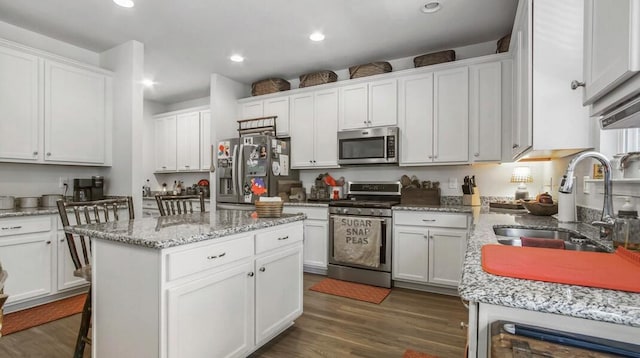 kitchen featuring a kitchen island, appliances with stainless steel finishes, and white cabinets