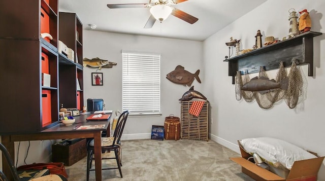 office area featuring light carpet, baseboards, and a ceiling fan