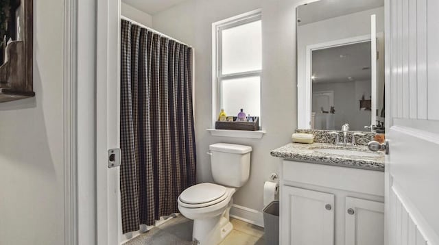 bathroom with baseboards, vanity, toilet, and tile patterned floors