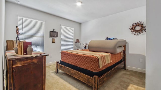 bedroom with light carpet and baseboards