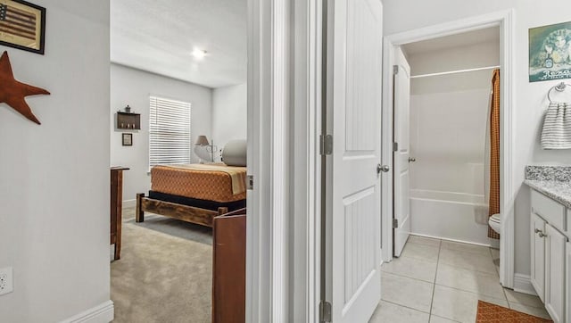 ensuite bathroom with shower / bath combo, connected bathroom, toilet, tile patterned flooring, and vanity