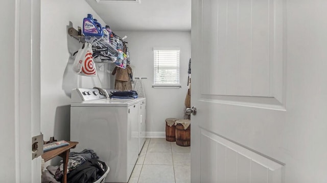 clothes washing area featuring laundry area, light tile patterned floors, baseboards, and separate washer and dryer