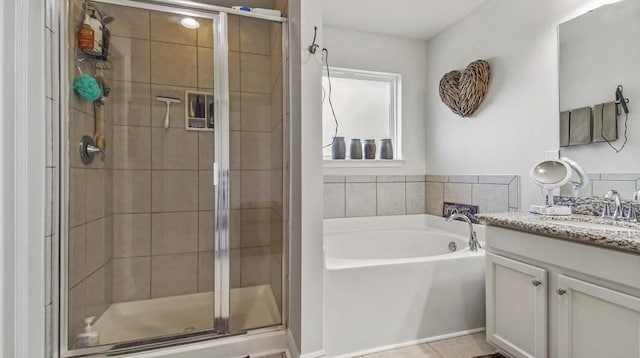 full bathroom featuring tile patterned flooring, a shower stall, a bath, and vanity